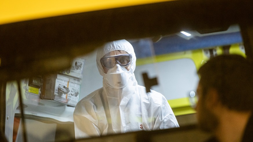 An ambulance health care worker of the Mendrisiotto Ambulance Service is puting on his mask and protection gear to practice for an Coronavirus emergency in Mendrision, Switzerland, Wednesday, February ...