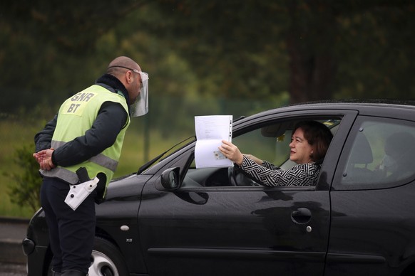 epa08353847 A police officer checks the documents of a driver of a vehicle during an inspection operation carried out by the GNR in the service area of Vendas Novas of the A6, to ensure compliance wit ...