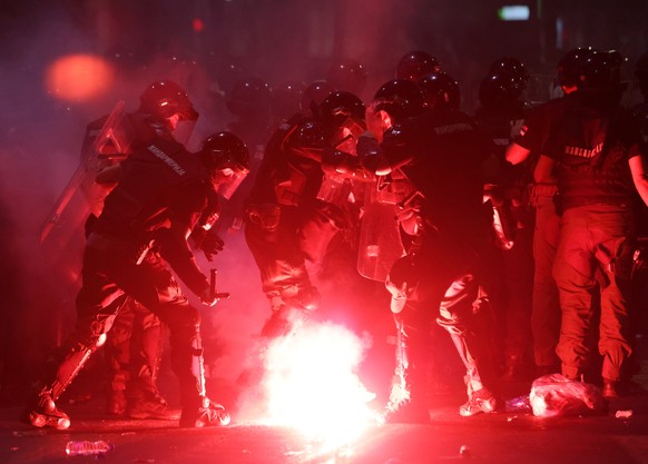 epaselect epa12203779 Riot police officers deal with a flare thrown by protesters after a student-led rally in Belgrade, Serbia, 28 June 2025. University students are demanding accountability and call ...