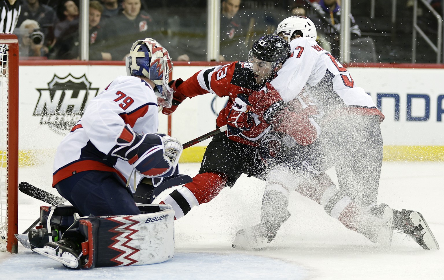 Washington Capitals defenseman Trevor van Riemsdyk (57) checks New Jersey Devils center Nico Hischier (13) in front of Capitals goaltender Charlie Lindgren (79) in the second period of an NHL hockey g ...