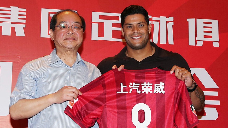 Brazilian soccer star Hulk, center, holds a jersey along with Sui Guoyang, left, general manager of the Shanghai SIPG FC, at a press conference in Shanghai Friday, July 1, 2016. Shanghai SIPG signed B ...