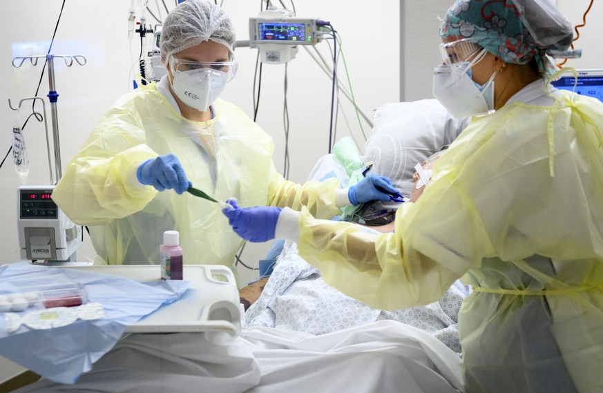 epa08799740 Medical workers treat a patient with Covid-19 in the intensive care unit at the eHnv hospital (Etablissements Hospitaliers du Nord Vaudois) during the coronavirus disease (COVID-19) outbre ...