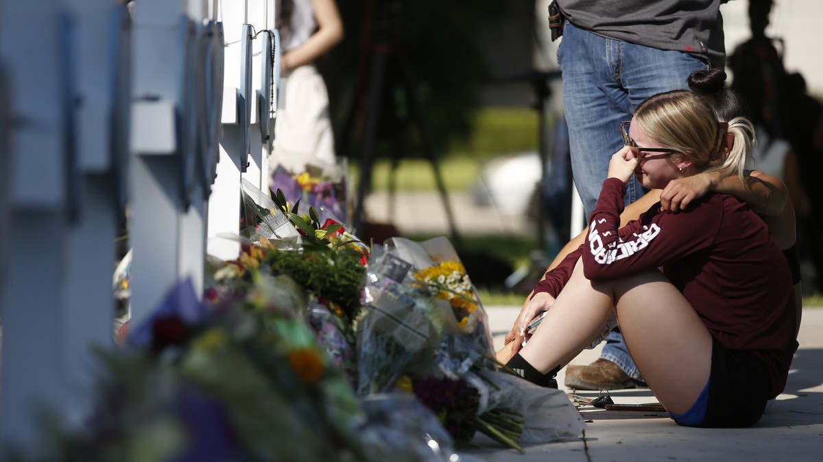 A woman reacts as she pays her respects at a memorial site for the victims killed in this week's elementary school shooting in Uvalde, Texas, Thursday, May 26, 2022. (AP Photo/Dario Lopez-Mills)
