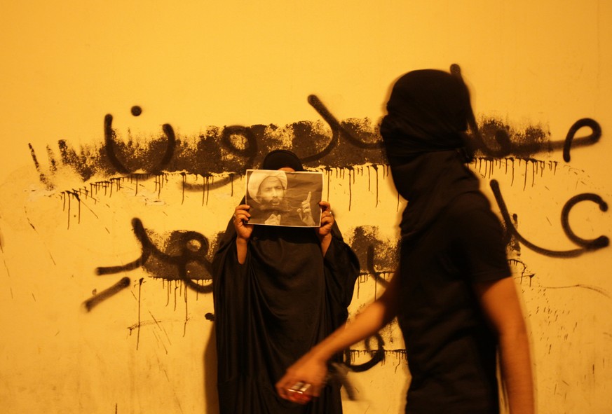 Protest in Bahrain im Oktober 2014: Die Frau hält ein Bild des schiitischen Geistlichen&nbsp;Nimr al-Nimr hoch, der nach Demonstrationen in Bahrain in saudische Gefangenschaft kam.<br data-editable="remove">