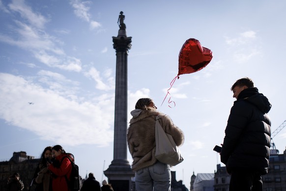 epa11895956 A couple carries a heart shaped balloon as they visit Trafalgar Square in London, Britain, 14 February 2025. Valentine's Day is considered a day of love and celebrated in the UK and m ...