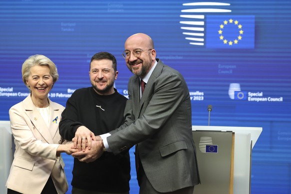 From left, European Commission President Ursula von der Leyen, Ukraine&#039;s President Volodymyr Zelenskyy, center, and European Council President Charles Michel join hands after addressing a media c ...