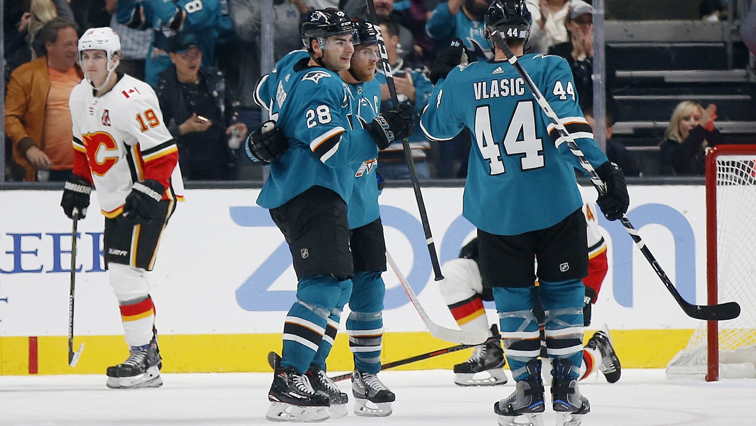 Calgary Flames&#039; Matthew Tkachuk (19) skates away as the San Jose Sharks&#039; Timo Meier (28), Joe Pavelski (8), center, and Marc-Edouard Vlasic (44) celebrate a goal in the third period of an NH ...