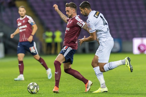 Le joueur de Lugano Akos Kecskes, droite, lutte pour le ballon contre le joueur de Servette Sebastien Wuethrich, gauche, lors de la rencontre de football de Super League entre le Servette FC et le FC  ...