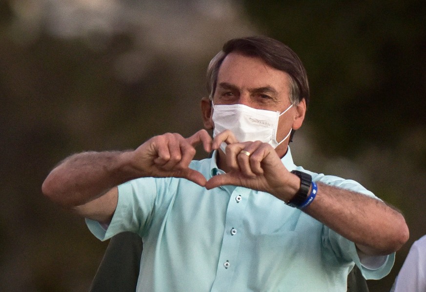 epa08565700 (FILE) - Brazilian President Jair Bolsonaro greets supporters during the daily flag-lowering ceremony at the Alvorada Palace, in Brasilia, Brazil, 22 July 2020 (reissued 25 July 2020). Acc ...