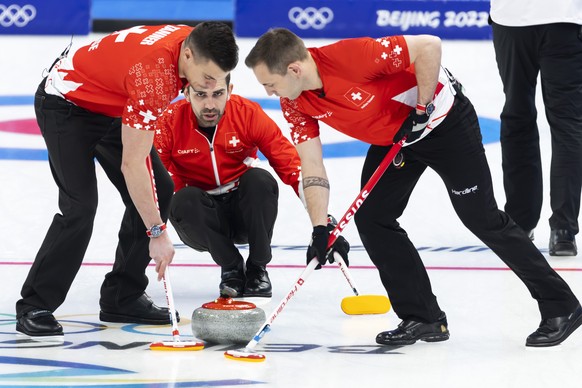 Switzerland skip Peter De Cruz, right, directs his teammates Valentin Tanner, left, and Sven Michel, right, during the men's Round Robin #3 game between Switzerland and Team ROC (Russia) at the N ...
