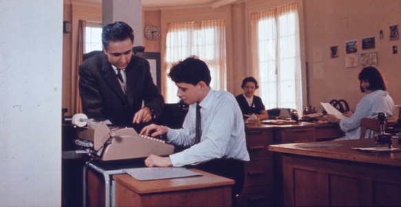 Chef und Lehrling bei der Arbeit: ein Büro in den 80er-Jahren.