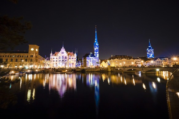 Zurich&#039;s Town house, center, and the Fraumuenster church, center right, are illuminated during the Silvesterzauber light show by artist Gerry Hofstetter on various buildings in the Limmatquai are ...