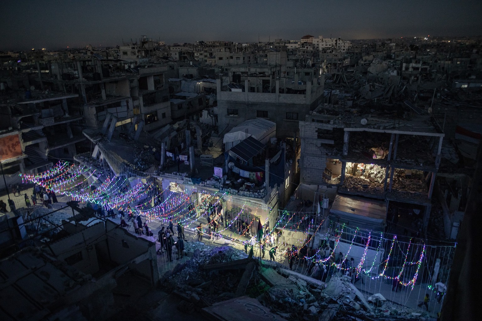 epa11931188 Palestinians hang decorations next to their destroyed homes in preparation for the holy month of Ramadan in Khan Yunis, southern Gaza Strip, 28 February 2025. The first day of Ramadan, the ...