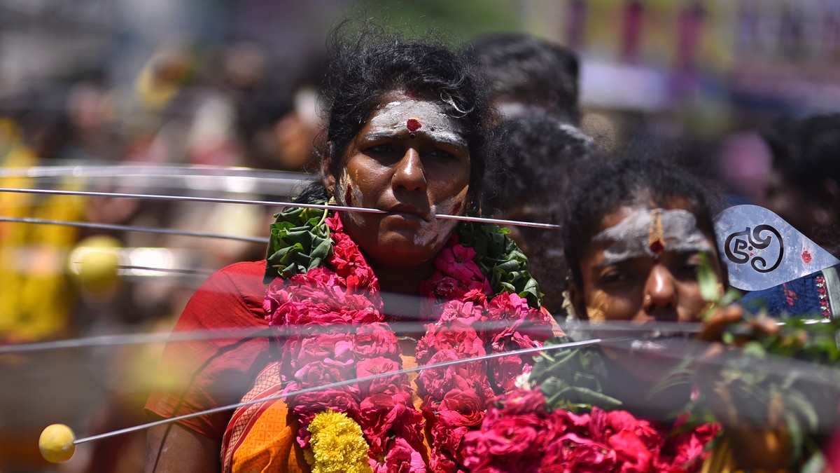 epa10777098 Hindu devotees with their cheeks pierced with metal skewers walk during a procession to mark the 'Aadi' festival, near Nagavalli Amman temple, in Chennai, India, 30 July 2023. Th ...
