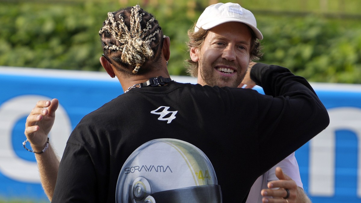 epa10873749 German former Formula One driver Sebastian Vettel (R) hugs British Formula One driver Lewis Hamilton of Mercedes-AMG Petronas prior the 'Buzzin? Corner' event at the Suzuka Circu ...