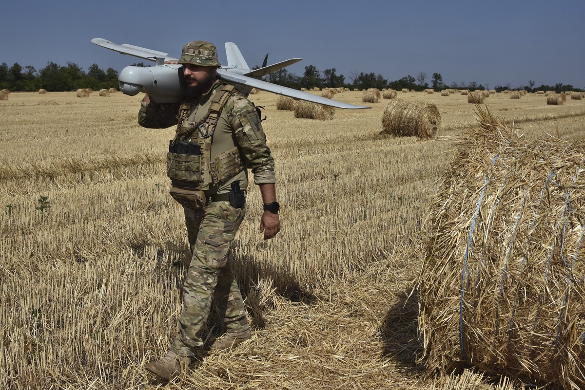 A soldier of Ukraine's National Guard 15th Brigade carries a reconnaissance drone Leleka on a wheat field to determine Russian positions near the front line in Zaporizhzhia region, Ukraine, Monda ...