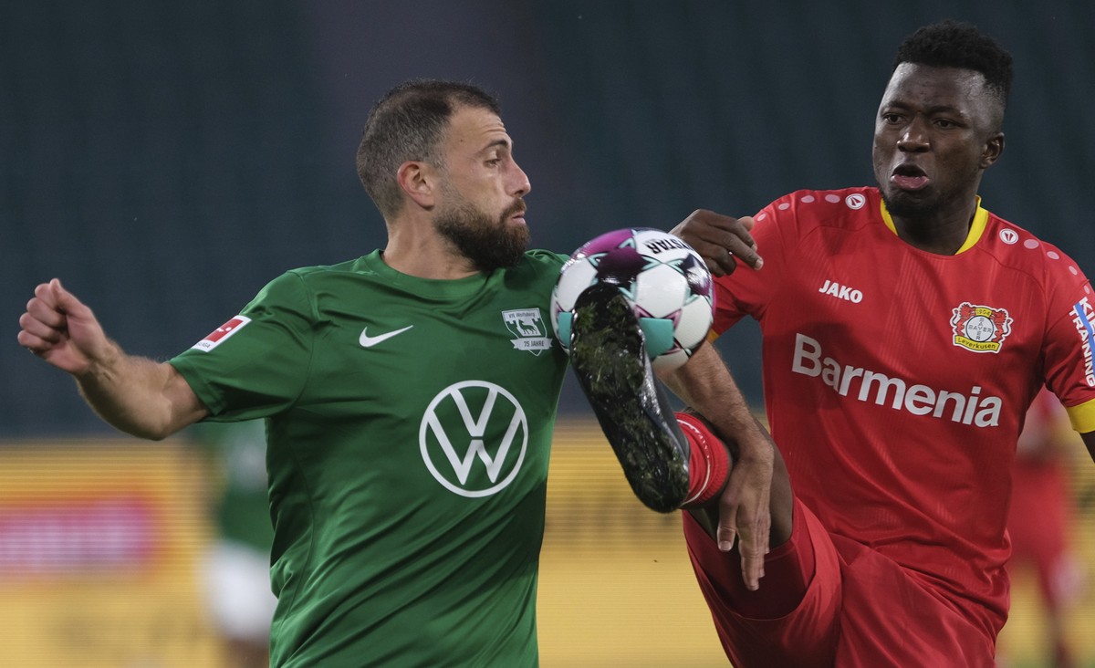 Wolfsburg's Admir Mehmedi, left, and Leverkusen's Edmond Tapsoba battle for the ball during the German Bundesliga soccer match between Wolfsburg and Bayer Leverkusen in the Volkswagen Arena, ...