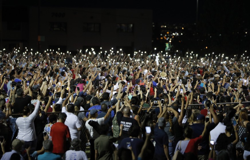 People raise their arms in the air during a vigil for victims of Saturday&#039;s mass shooting at a shopping complex Sunday, Aug. 4, 2019, in El Paso, Texas. (AP Photo/John Locher)