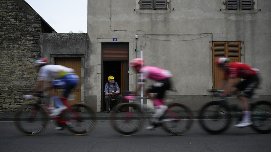 A man watches Italy&#039;s Daniel Oss, left, Costa Rica&#039;s Andrey Amador, center, and France&#039;s Matis Louvel, right, pass in the breakaway during the eleventh stage of the Tour de France cycli ...
