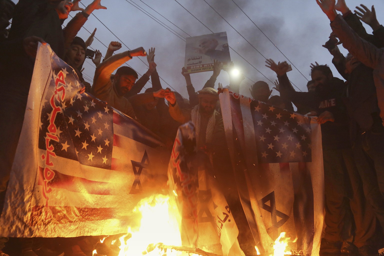 Pakistani Shiite Muslims burn representations of Israeli and U.S. flags during a rally in protest of the recent U.S. attack in Iraq that killed Iranian Gen. Qassem Soleimani, outside the U.S. Consulat ...