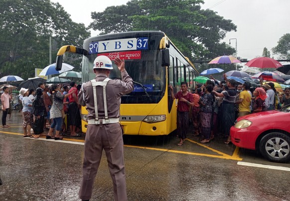 epa10310034 People gather around a bus carrying inmates as they are released from the Insein Prison in Yangon, Myanmar, 17 November 2022. The Myanmar military council granted amnesty to over five thou ...