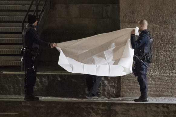 epa05682671 Policemen inspect the site where a body is found under the Gessnerbruecke bridge, after the shooting attacks at the Islamic center in Zurich, Switzerland, 19 December 2016. Three people we ...