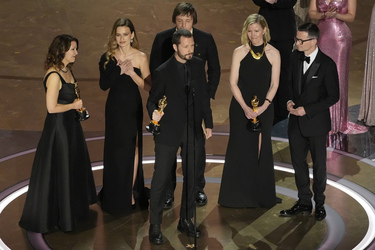 Raney Aronson-Rath, from left, Vasilisa Stepanenko, Mstyslav Chernov, Evgeniy Maloletka, Michelle Mizner, and Derl McCrudden accept the award for best documentary feature film for "20 Days in Mar ...