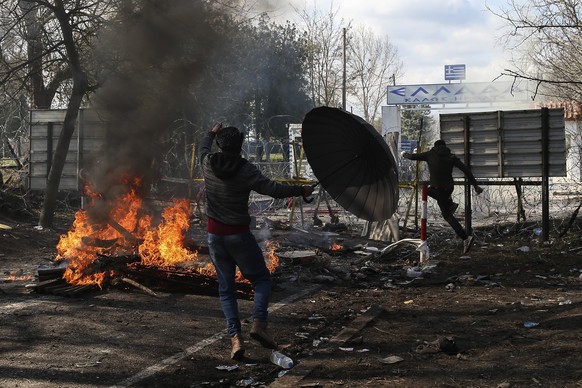 Migrants who are trying to enter Greece from the Pazarkule border gate, Edirne, Turkey, approach the border gate during clashes in Kastanies village, Saturday, Feb. 29, 2020. Refugees and migrants mas ...