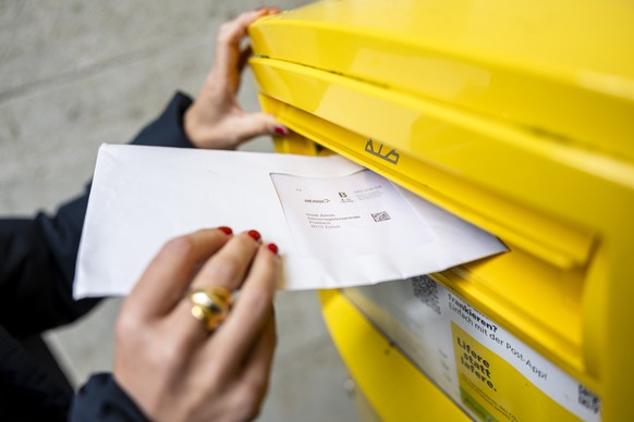 Eine Frau wirft ein Couvert mit Abstimmungsunterlagen fuer die Briefliche Stimmabgabge in einen Briefkasten der Post, am Dienstag, 17. September 2024 in Zuerich. .Die Schweizer Stimmbevoelkerung stimm ...