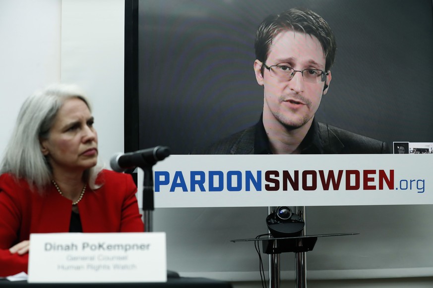 Dinah PoKempner, left, general council for Human Rights Watch, listens as Edward Snowden speaks on a television screen via video link from Moscow during a news conference to call upon President Barack ...