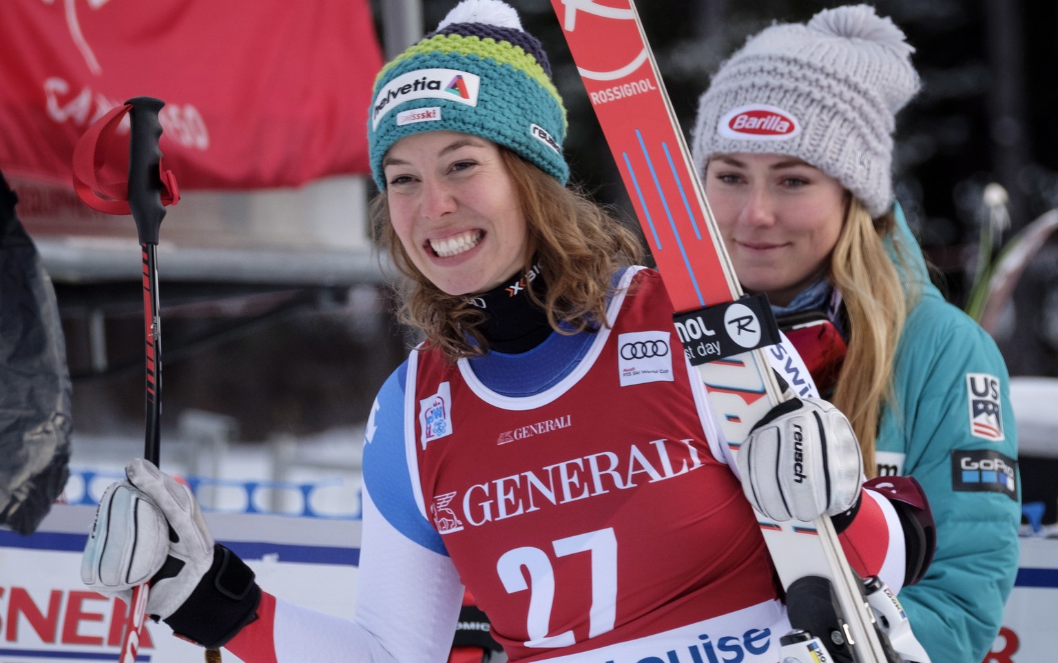 Michelle Gisin, left, of Switzerland, celebrates her third-place finish as she walks to the podium while winner Mikaela Shiffrin, of the United States, looks on following the women&#039;s World Cup do ...