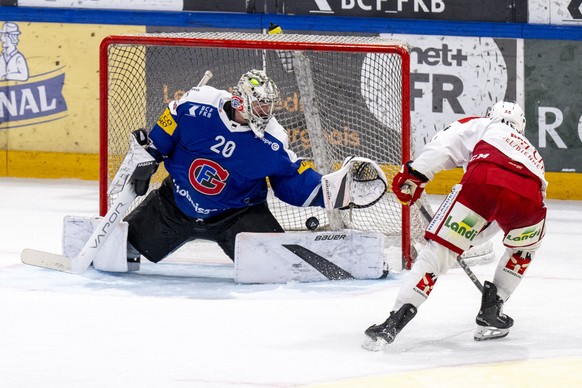 Torhueter Reto Berra (HCFG), links, muss gegen Anthony Greco (EHCB) den Treffer zum 3-4 hinnehmen im Spiel der Eishockey National League zwischen Fribourg-Gotteron, HCFG, und EHC Biel-Bienne, EHCB, vo ...