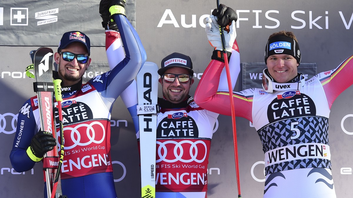 From left, second placed Italy's Dominik Paris, first placed Switzerland's Beat Feuz, , and third placed Germany's Thomas Dressen celebrate at the end of their alpine ski, World Cup men ...