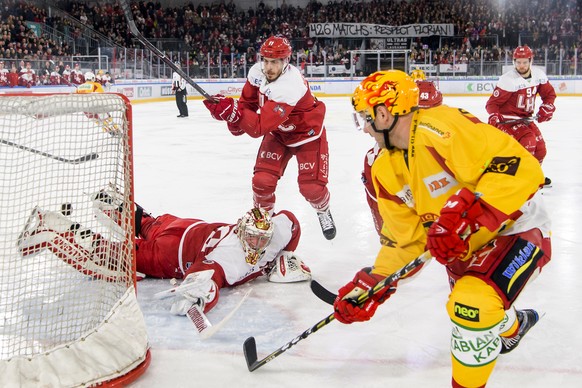 Le gardien lausannois Cristobal Huet, gauche, lutte pour le puck avec le Top scorer bernois Aaron Gagnon, droite, lors de la derniere rencontre du tour de placement du championnat suisse de hockey sur ...