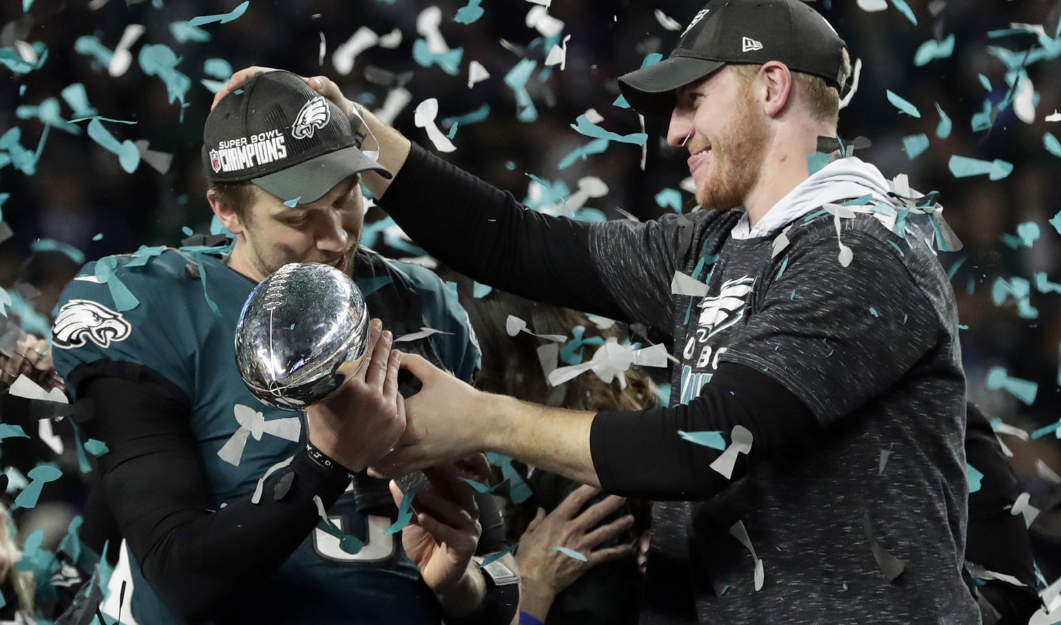 FILE - In this Feb. 4, 2018 photo, Philadelphia Eagles quarterback Carson Wentz, right, hands the Vincent Lombardi trophy to Nick Foles after winning the NFL Super Bowl 52 football game against the Ne ...