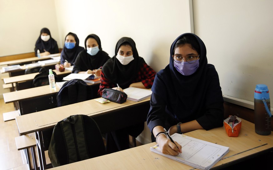 epa08648213 Iranian high school girls wearing face masks attend a class at the Bamdad Parsi private school during the first day of reopening schools, north of Tehran, Iran, 05 September 2020. Media re ...