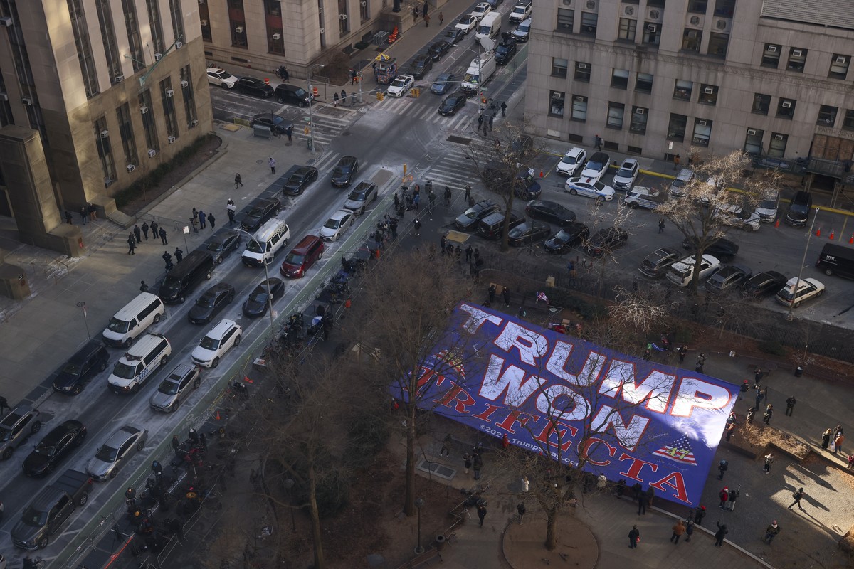 Supporters for President-elect Donald Trump display a banner outside Manhattan criminal court during the sentencing hearing in Trump's hush money case, Friday, Jan. 10, 2025, in New York. (AP Pho ...