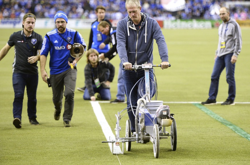 The grounds crew make last minute adjustments delaying the start of the first leg of the MLS Eastern Conference final with the Montreal Impact facing the Toronto FC at the Olympic Stadium Tuesday, Nov ...