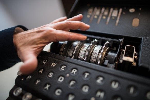 epa05952392 An employee shows an Enigma M4 cipher machine from 1942 during a press preview at the Deutsches Museum in Munich, Germany, 09 May 2017. The Deutsches Museum received a cryptography collect ...