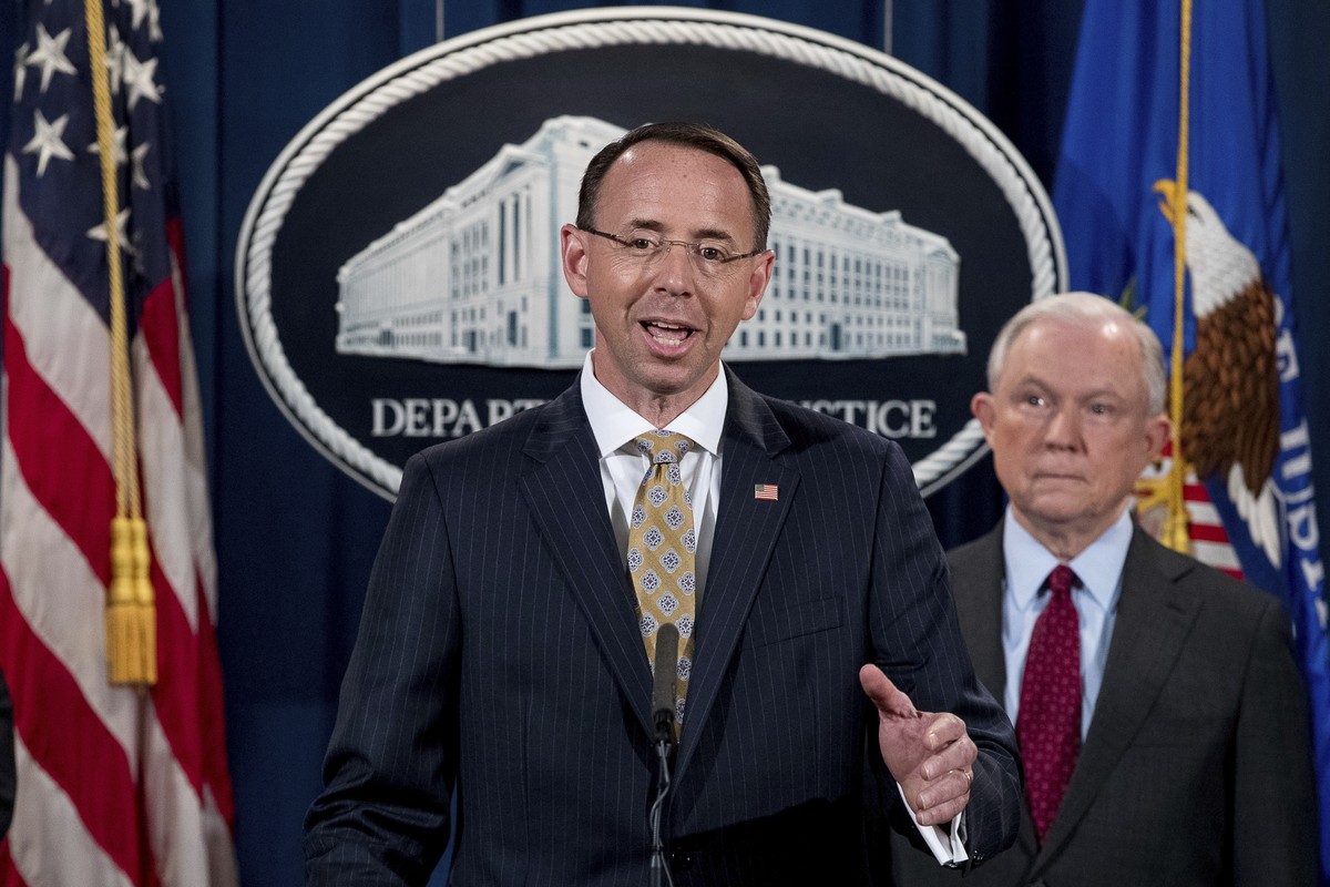 Deputy Attorney General Rod Rosenstein, center, accompanied by Attorney General Jeff Sessions, right, speaks at a news conference to announce an international cybercrime enforcement action at the Depa ...