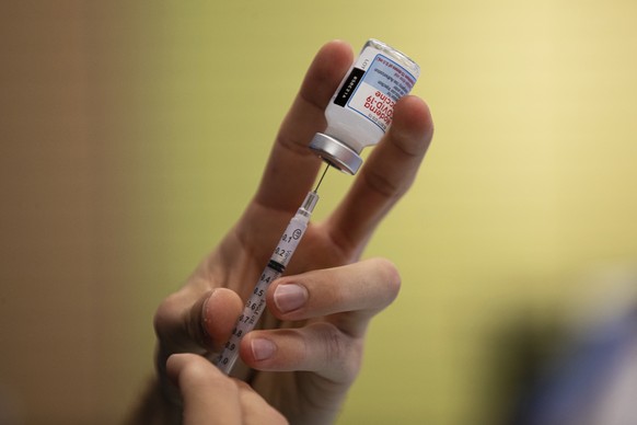 Alex Lewandowski prepares a dose of a Moderna COVID-19 vaccine on Thursday, Nov. 4, 2021, at a vaccine center in Barboursville, W.Va. (Sholten Singer/The Herald-Dispatch via AP)