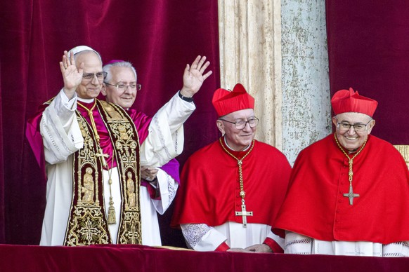 Newly elected Pope Leo XIV, left, formerly Cardinal Robert Francis Prevost, appears with, from left, Master of Ceremonies Archbishop Diego Giovanni Ravelli, Cardinal Pietro Parolin, and Cardinal Vinko ...