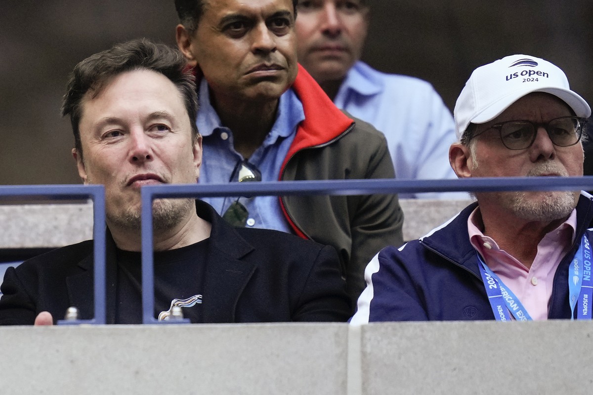 Elon Musk, left, watches play between Jannik Sinner, of Italy, and Taylor Fritz, of the United States, during the men's singles final of the U.S. Open tennis championships, Sunday, Sept. 8, 2024, ...