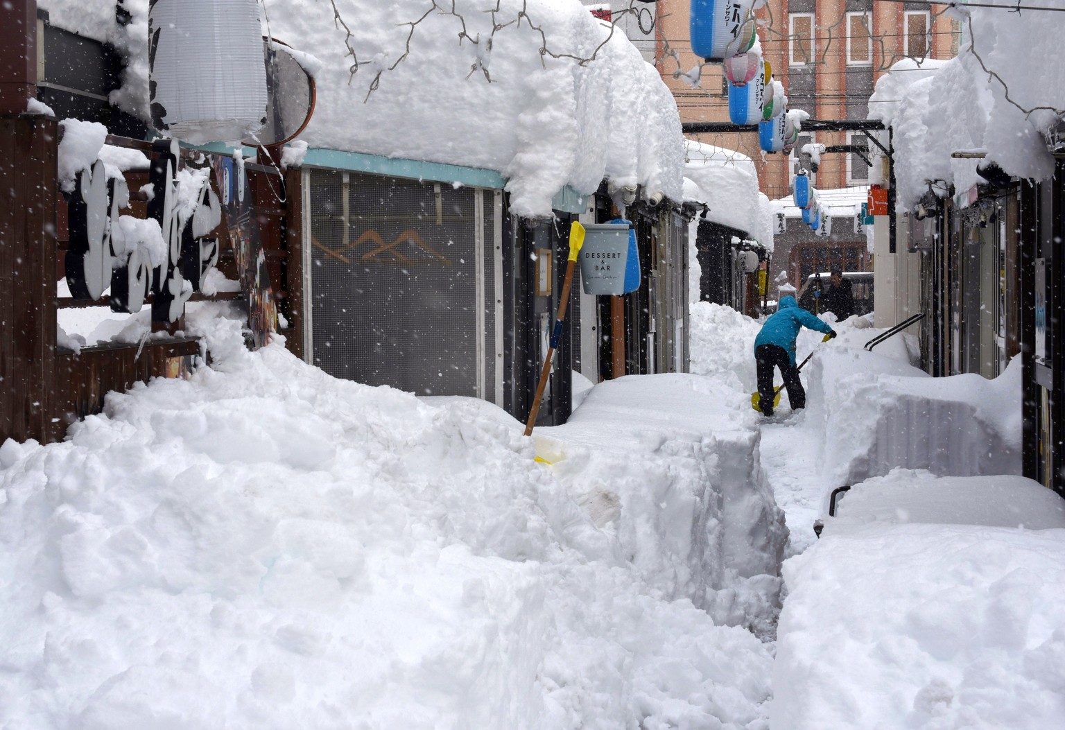 epa11875695 A man digs snow following heavy snowfall in Obihiro, Hokkaido, northern Japan, 04 February 2025 (issued 05 February 2025). On 05 February 2025, the coldest air of the winter persisted over ...