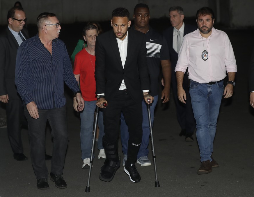 Using crutches because of an injured right ankle, Brazil's soccer player Neymar leaves a police station where he answered questions about rape allegations against him in Sao Paulo, Brazil, Thursday, J ...