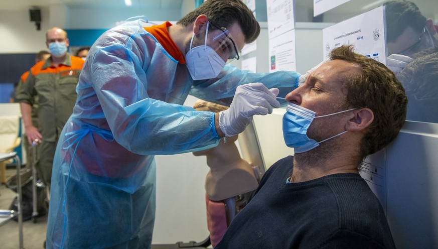 epa08810349 A member of the Swiss Civil Protection takes a nose swab sample from an instructor for a polymerase chain reaction (PCR) for a SARS-CoV-2 Rapid Antigen Test, during the training of Members ...