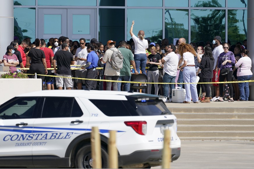 Families are addressed by an unidentified person at center, as they wait to be reunited with their children at the Mansfield ISD Center For The Performing Arts, Wednesday, Oct. 6, 2021, in Mansfield,  ...