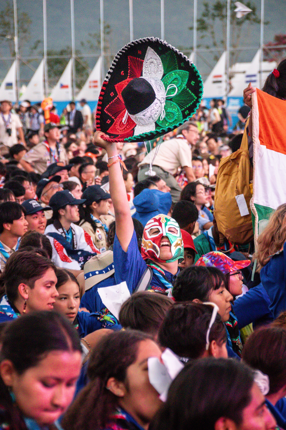 A young mexican scout yelling while holding his sombrero and using a luchador mask celebrating while at the opening ceremony of the 25th World Scout Jamboree. Photo by Andrea Sánchez.
