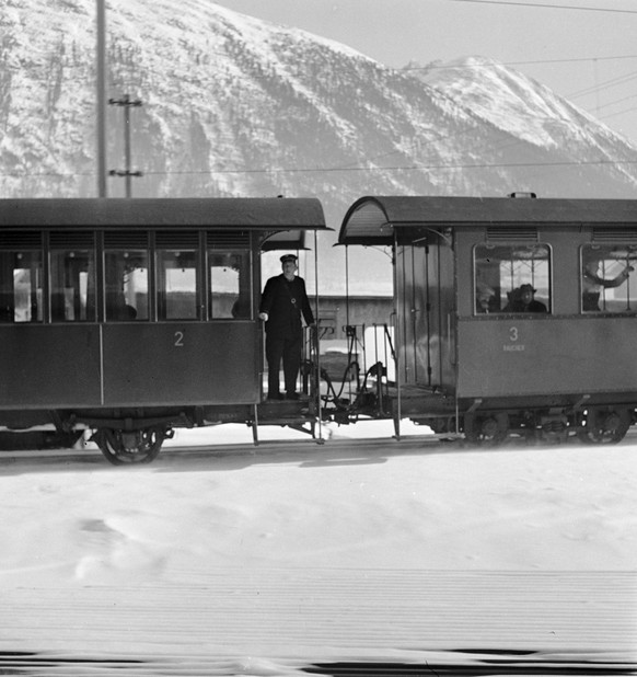 Personenwagons der zweiten und dritten Klasse der Rhatischen Bahn zwischen Landquart und Klosters bei winterlichen Verhaeltnissen, aufgenommen am 15. Januar im Kriegsjahr 1944. Ein Schaffner steht auf ...