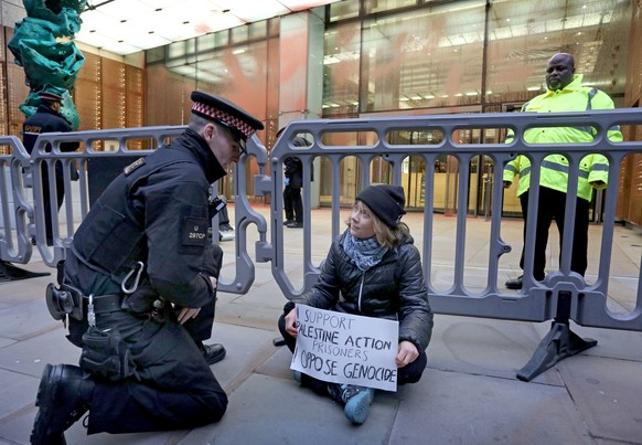 In this photo, released by 'Prisoners for Palestine' on Tuesday, Dec. 23, 2025, climate activist Greta Thunberg, center, sits in front of offices of Aspen Insurance in London, England, durin ...